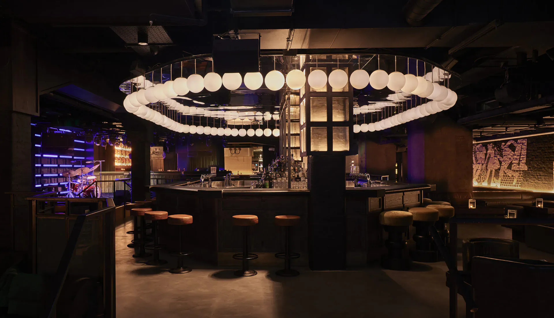 Modern circular bar at Stereo Covent Garden with glowing pendant lights and neon accents, live music venue in London