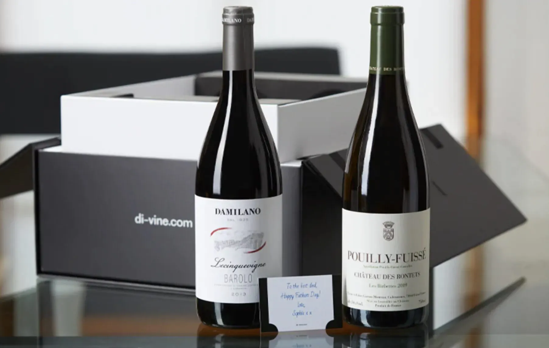 Open black Di-Vine gift box with Duriland Champagne and Pouilly-Fuissé wine bottles on table, d-vine.com featured.