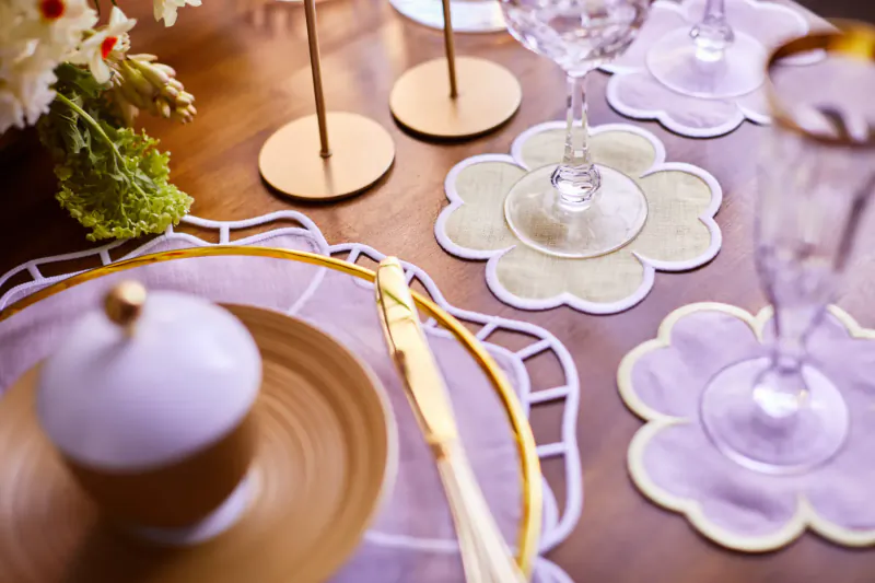 Luxury close-up table setting with Truffle Bee: cupcake on plate, knife, champagne glasses on floral placemats, flowers.