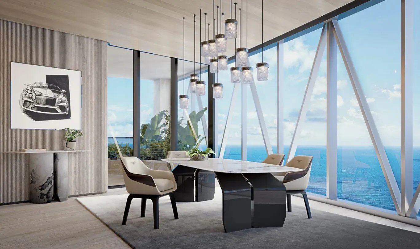 Modern black dining table and chairs in Bentley Residences Miami penthouse with ocean view and car artwork.