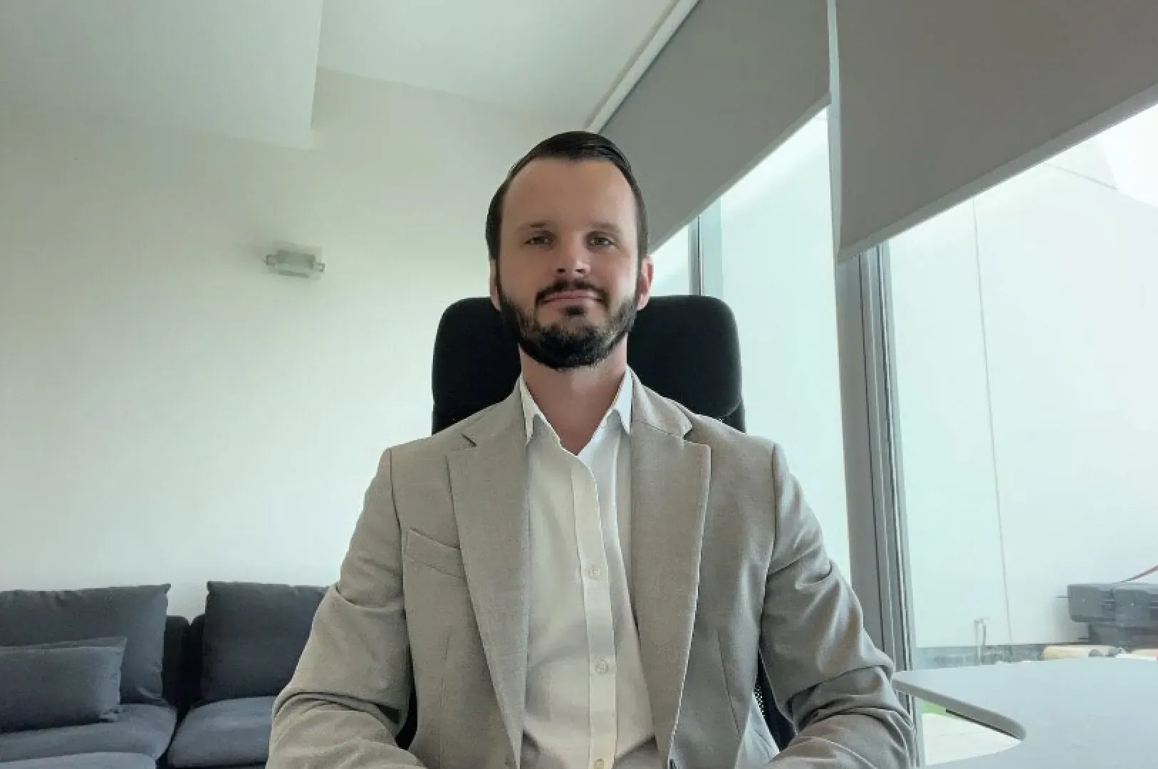 Lee Percival, CEO of Templar Protection, smiling in light gray suit, seated in modern office for Luxuria Lifestyle interview