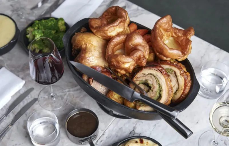 Sunday roast at Treadwell Restaurant: roast chicken, pork belly, Yorkshire puddings, carrots, gravy, wine on table