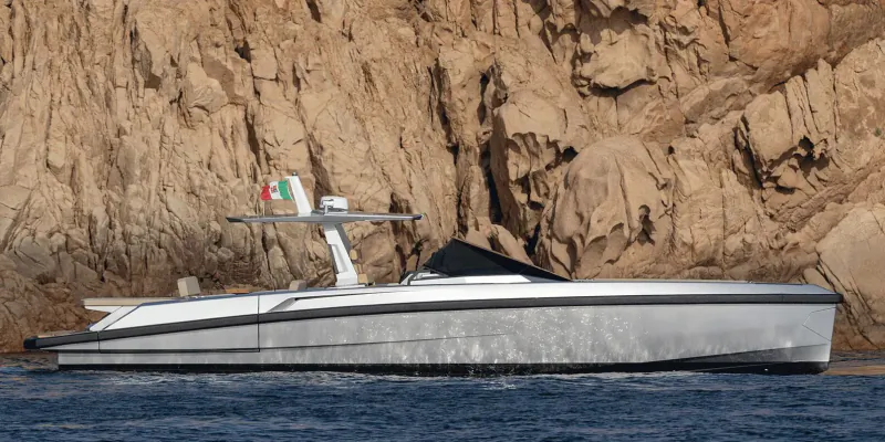 White Ferretti Yachts 720 with Italian flag on mast, sleek design, docked near rocky cliffs on blue sea