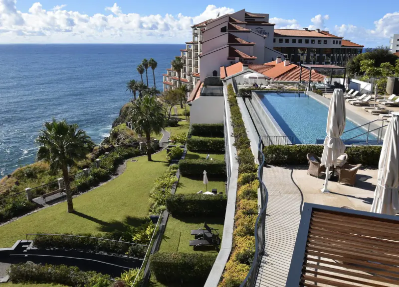 Les Suites Hotel at The Cliff Bay in Funchal, Madeira: clifftop infinity pool, lounge chairs, gardens, ocean view.