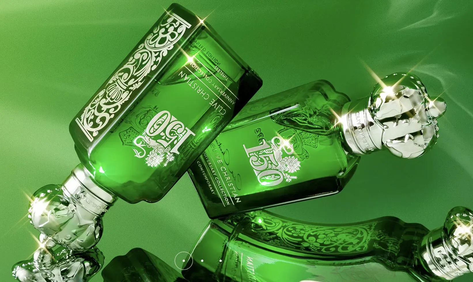 Two ornate green Clive Christian 1872 perfume bottles with crowns, elegantly overlapping on green background.