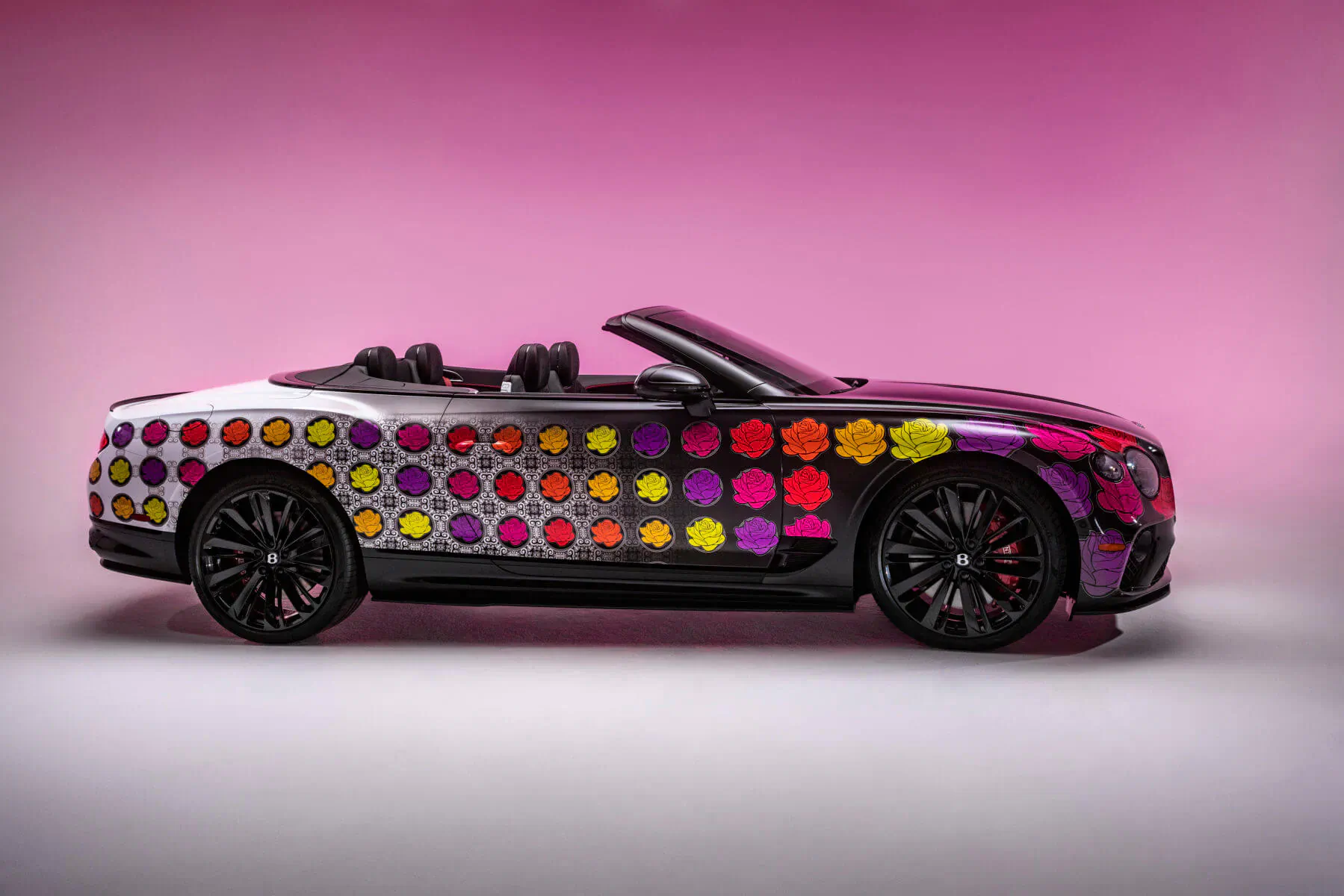 Bentley convertible with vibrant multicolored polka dot pattern on pink background