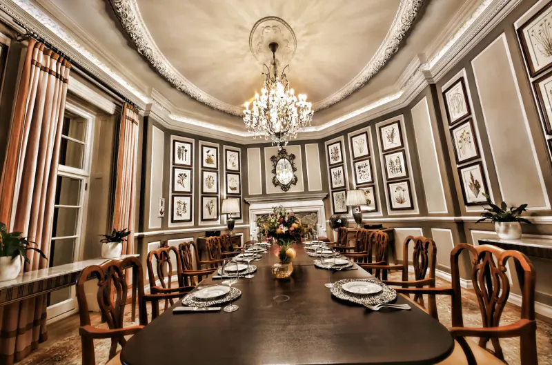 Elegant dining room at Mount Nelson with long wooden table set for afternoon tea, chandelier, artwork, and floral decor.