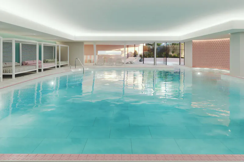 Luxurious indoor swimming pool at St Moritz Hotel in Cornwall with turquoise water, lounge areas, and large windows