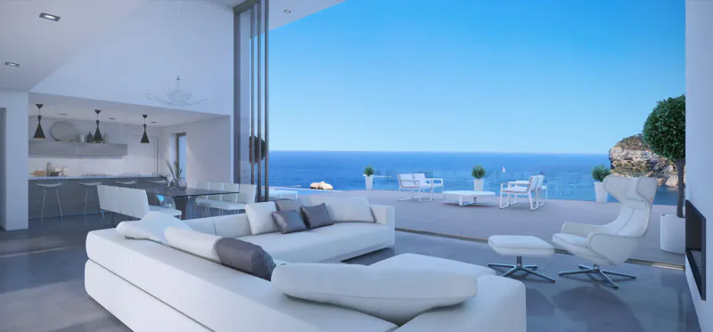 Modern white living room with L-shaped sofa, open kitchen, folding doors to terrace with sea view and cliffs.