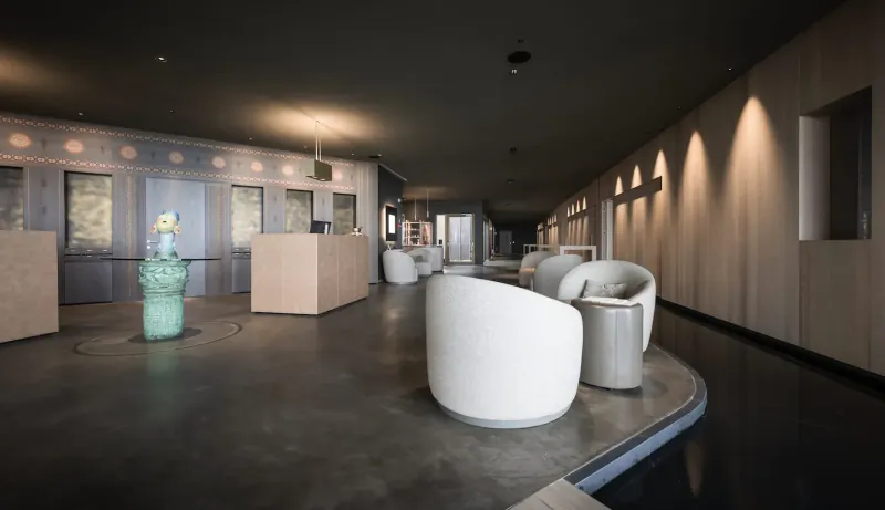 Modern hotel lobby with curved white lounge chairs, turquoise vase, wood-paneled walls, and warm lighting in ADLER Spa Resort Sicily.