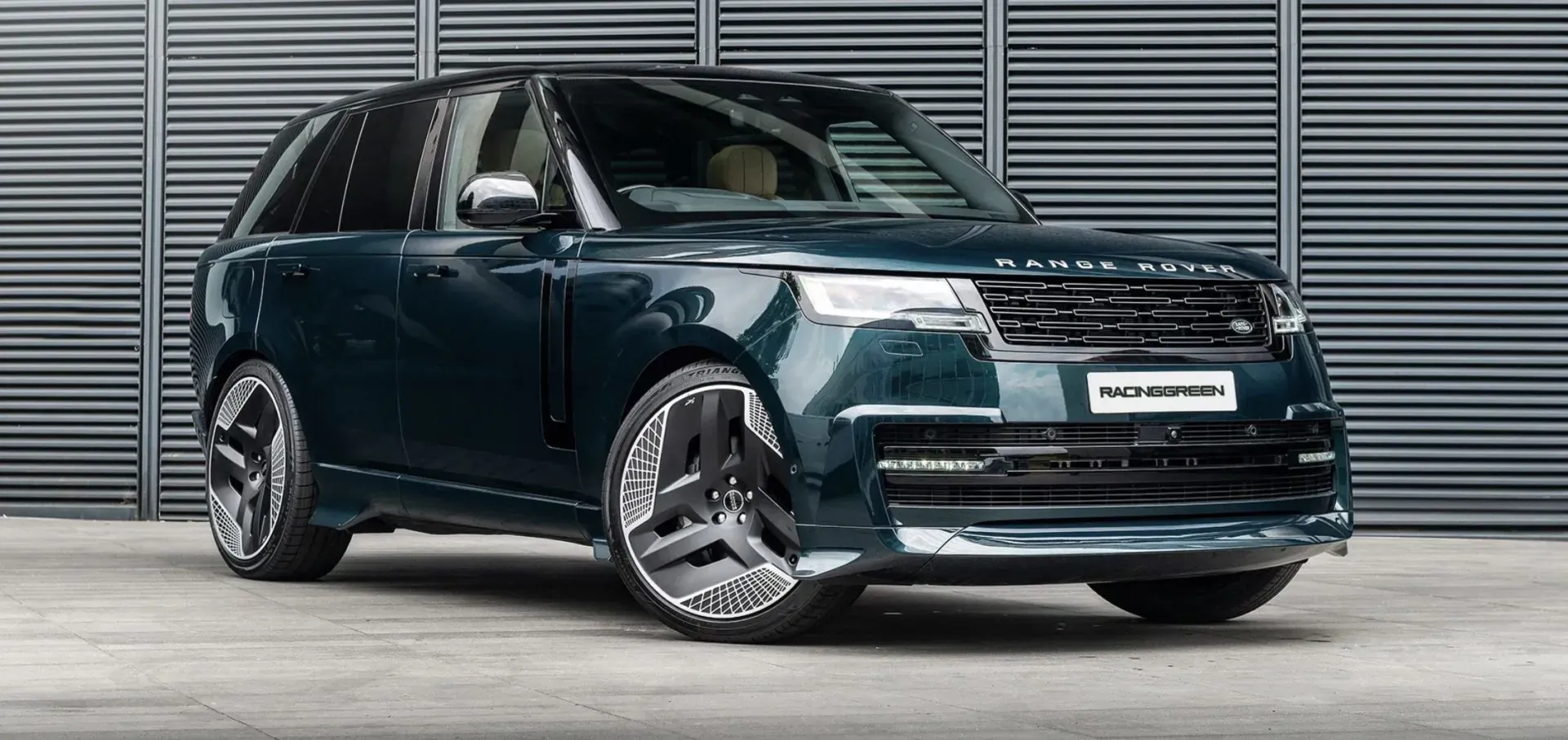 Racing Green Automotive's dark green Range Rover parked in front of modern louvered wall