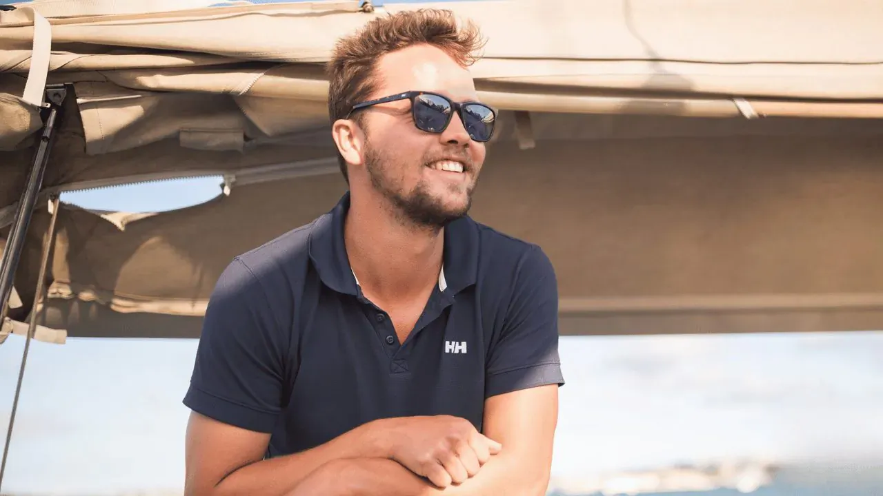 Daan Brinkers, CEO of Explore Yachting, smiles with arms crossed on yacht deck wearing Helly Hansen polo and sunglasses