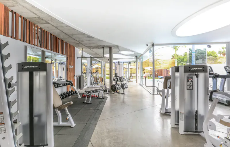 Spacious modern gym at Baobab Suites resort in Tenerife with cardio machines, weights, and glass walls