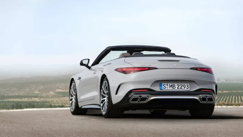 Rear view of silver Mercedes-AMG SL convertible on rural road with vineyards, license plate SB MB 725.