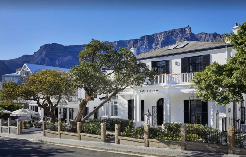 Cape Cadogan Boutique Hotel, white colonial building with Table Mountain backdrop, lush gardens, Cape Town.