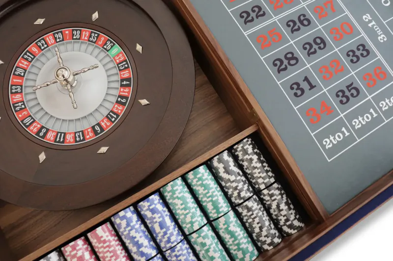 Luxury wooden roulette wheel with numbered betting board and colorful poker chips