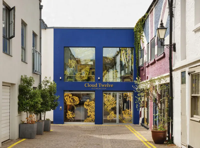 Cloud Twelve wellness centre facade with blue walls, gold signage, and plants in a narrow urban alley