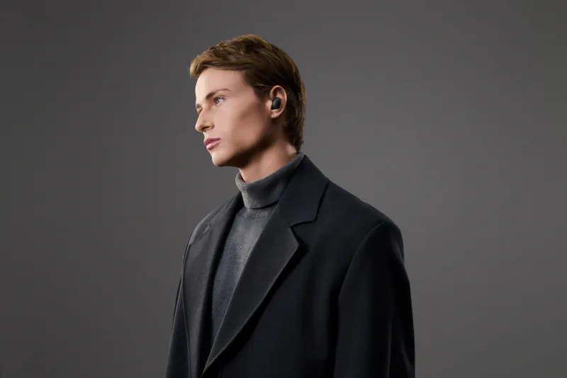 Side profile of man in black suit and turtleneck wearing Sony WF-1000XM6 wireless earbuds