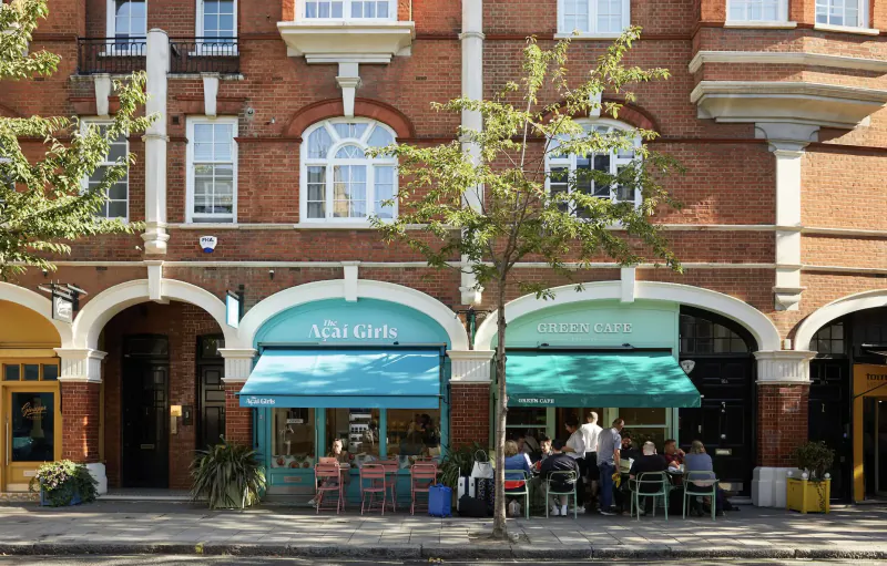 Eccleston Square Hotel London Gallery: turquoise 'M.A Girls' shopfront with outdoor seating, patrons dining under awnings on brick street.