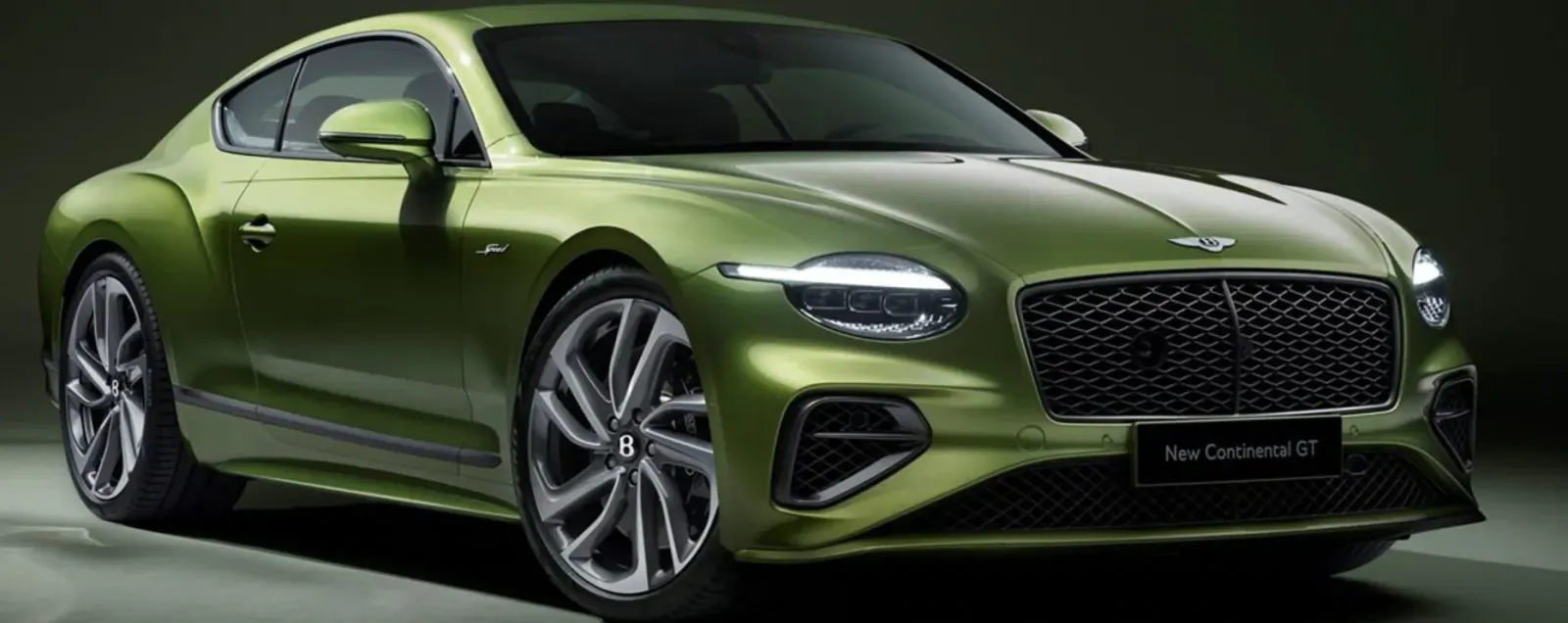 Emerald green Bentley Continental GT coupe, front view, with 'New Continental GT' badge, on dark studio background.