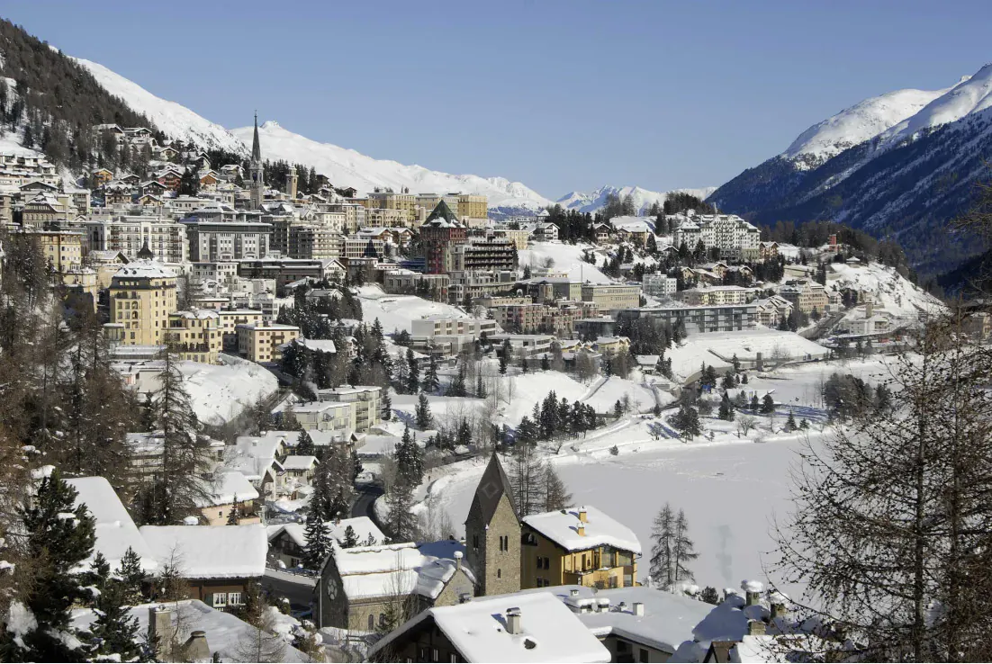 Panoramic view of snow-covered St. Moritz town and frozen lake with mountains, 39th Snow Polo World Cup 2024