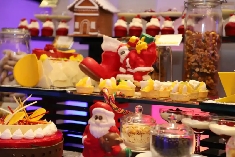 Festive Christmas dessert buffet at Lily Beach Resort with Santa figures, gingerbread houses, cakes, and treats