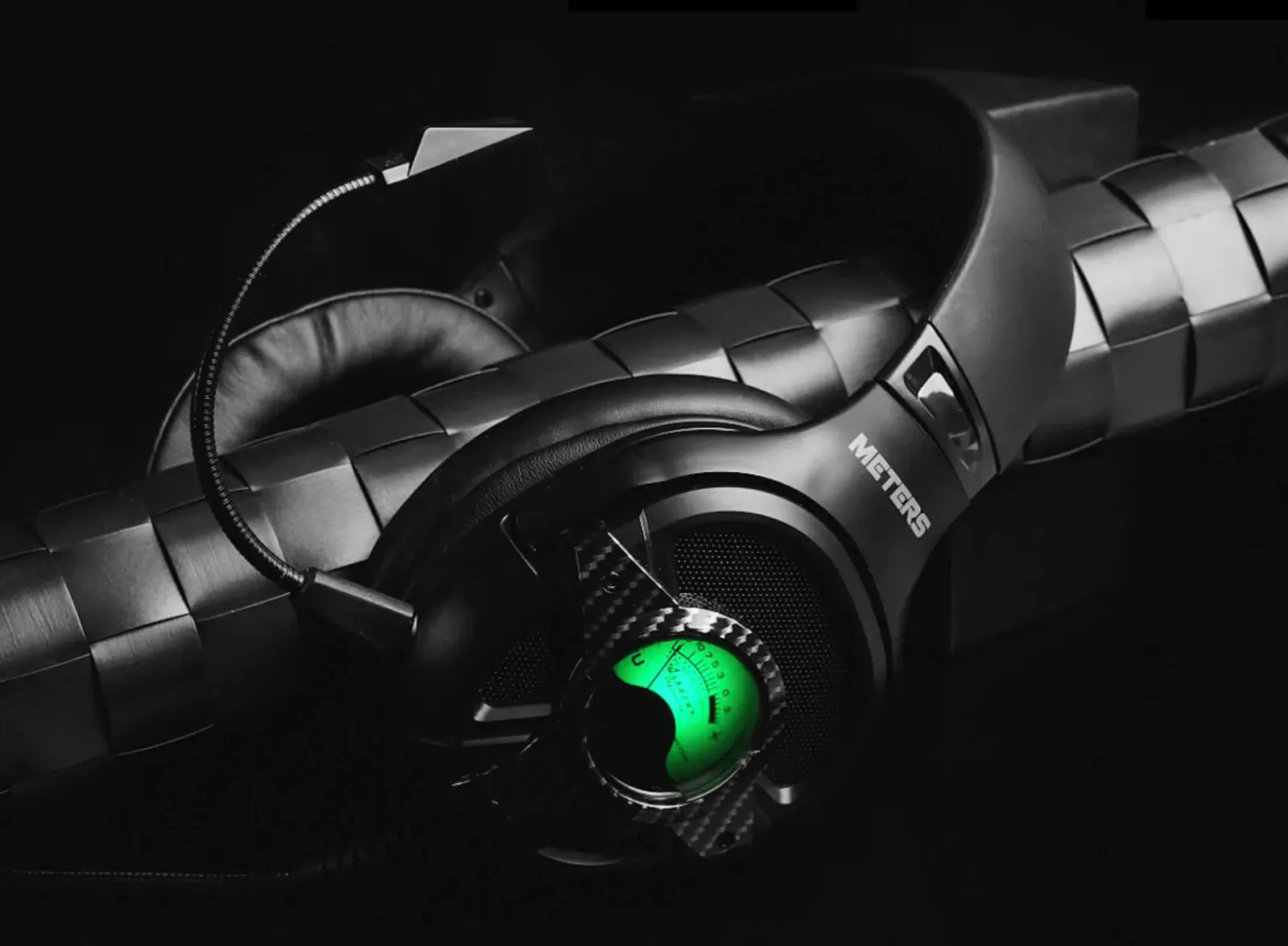 Black Meters gaming headset 'Level Up' with green glowing earcup, carbon fiber accents, and detachable mic on dark background