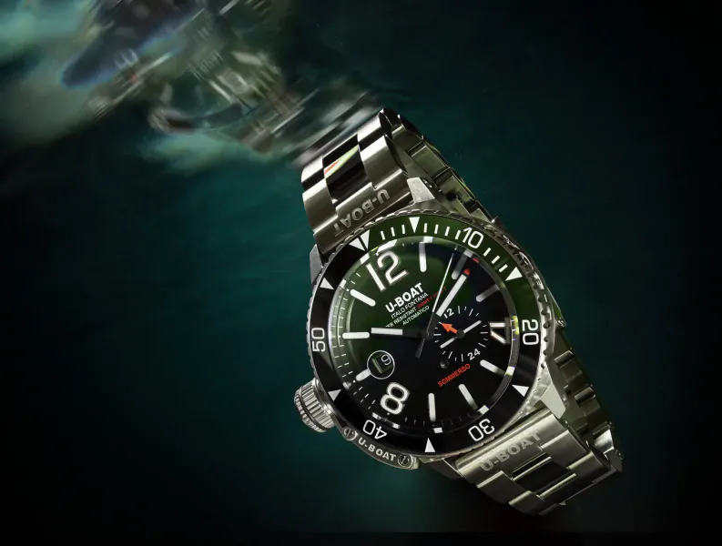 U-Boat Sommerso 46mm dive watch with green dial and stainless steel bracelet, angled underwater against teal background.
