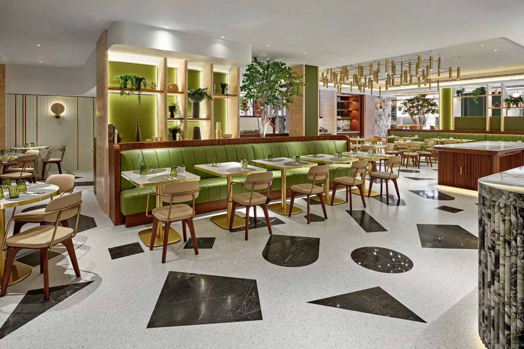 Park Corner Brasserie at London Hilton on Park Lane: modern interior with green velvet booths, plants, terrazzo floor, and pendant lights.