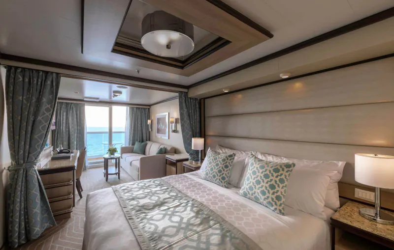Luxurious Princess Cruises stateroom with king bed, ocean view balcony, and elegant decor.