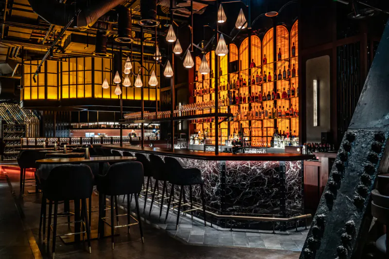 Lucky Cat by Gordon Ramsay: stylish Asian bar with glowing shelves of bottles, pendant lights, and swivel stools