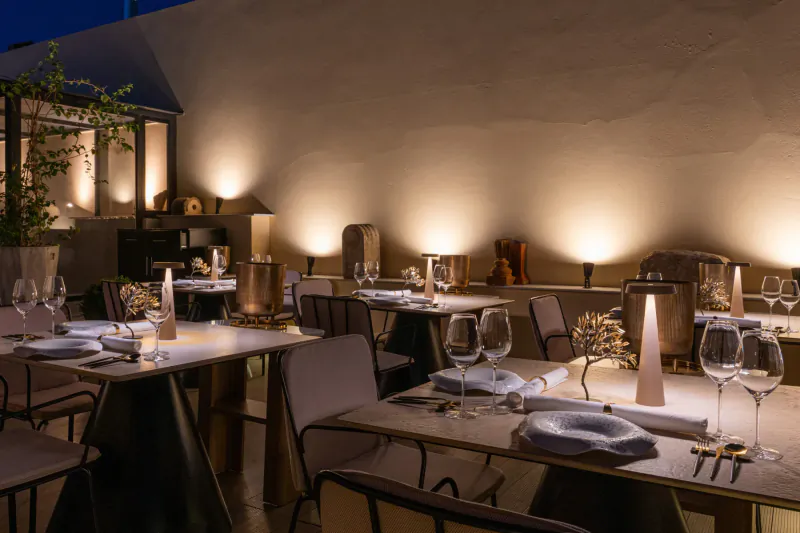 Elegant outdoor terrace dining at Makris Restaurant, Athens, with candlelit tables set for dinner at dusk.