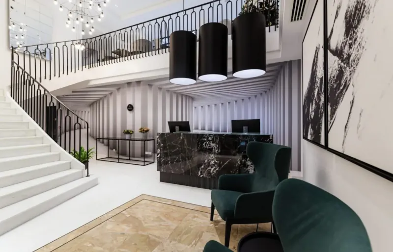 Modern luxury hotel lobby with marble reception desk, green armchairs, curved white staircase, black pendant lights, and abstract art.