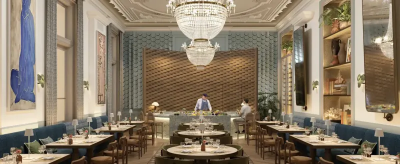 Elegant dining room at Grand Hotel Des Bains Kempinski St. Moritz with chandelier, blue art, brick wall, tables, and staff.
