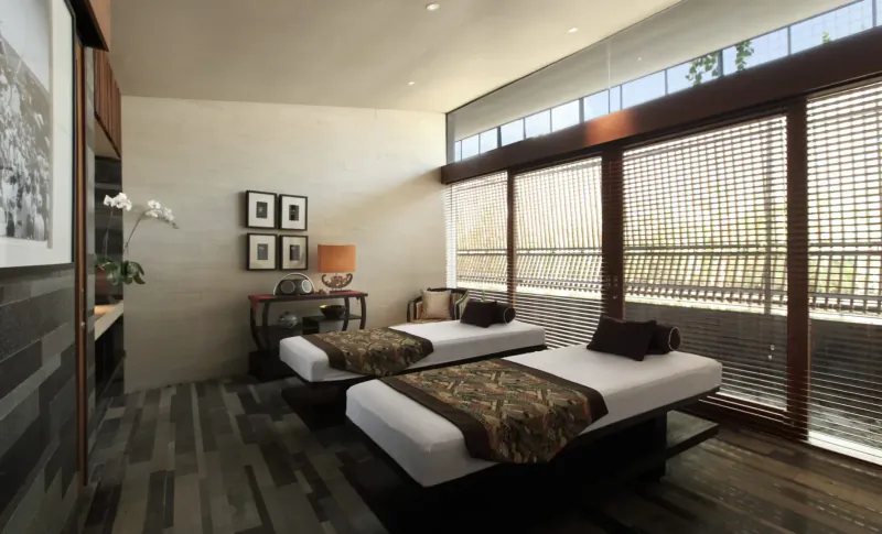 Luxurious Ametis Villa Bali bedroom with two twin beds, bamboo screens, orchids, and garden view.