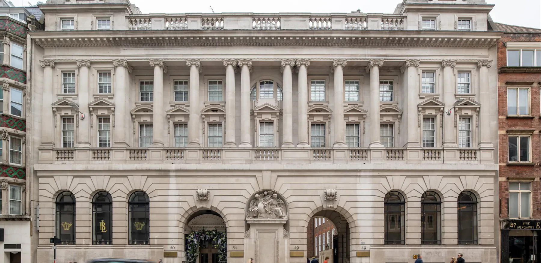 Apex Temple Court hotel, neoclassical stone building with columns and arches in London street.