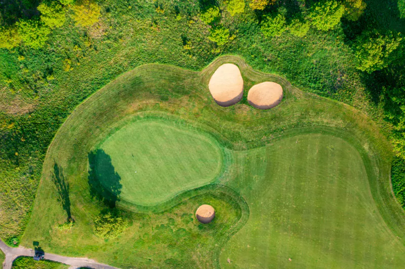 Aerial view of Chart Hills golf course green with bunkers and surrounding trees.