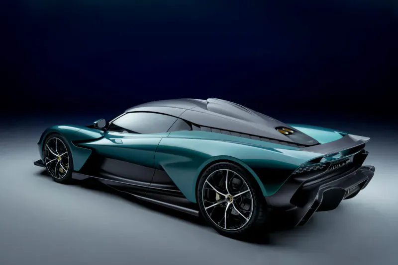 Rear three-quarter view of Aston Martin Valhalla hybrid supercar in teal with black accents on dark background