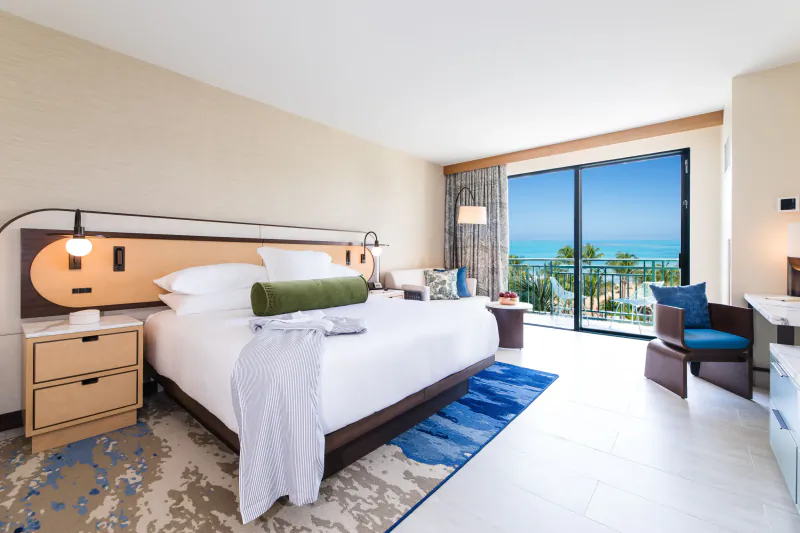 Luxurious Wyndham Puerto Rico Resort suite with king bed, balcony view of blue ocean and palm beach.