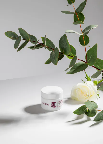 White Thirns cream jar on table with white rose and eucalyptus branches