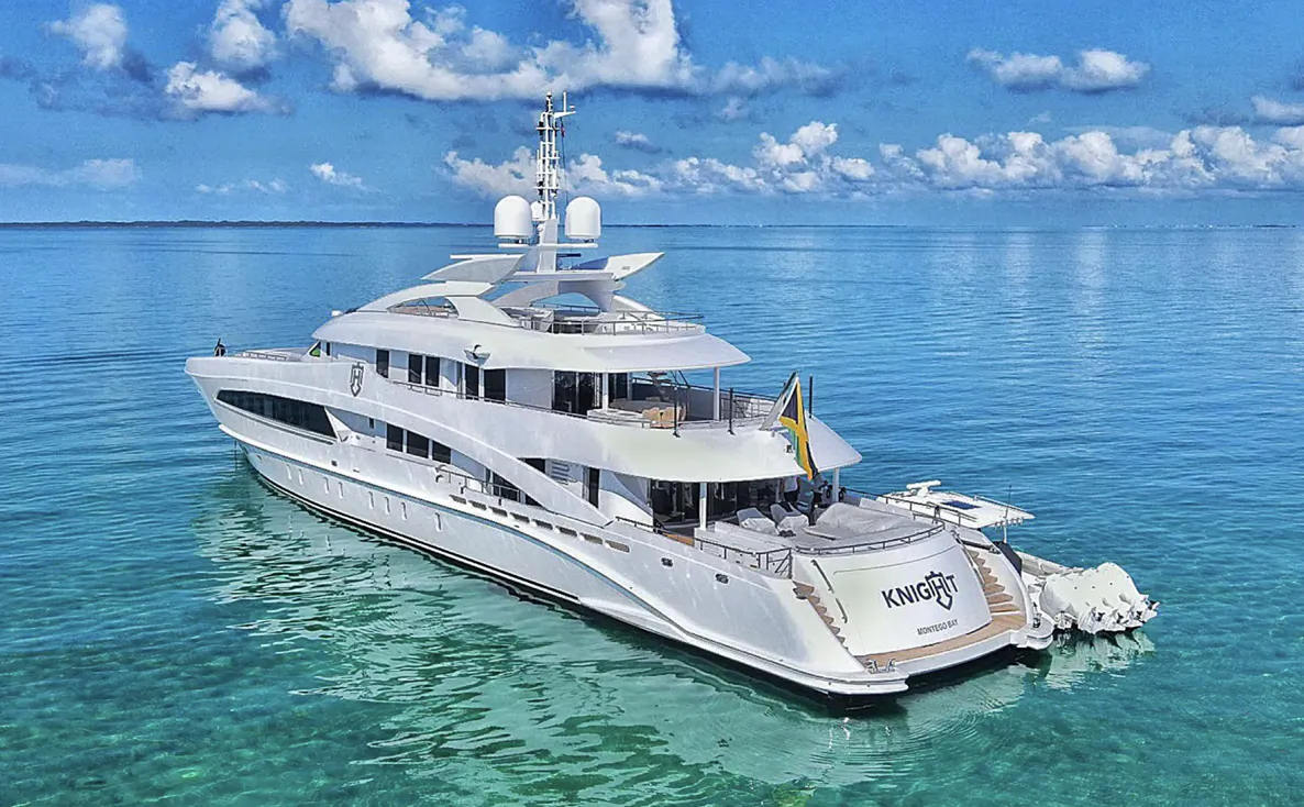 Luxury white superyacht Kangari anchored in calm turquoise waters under a blue sky