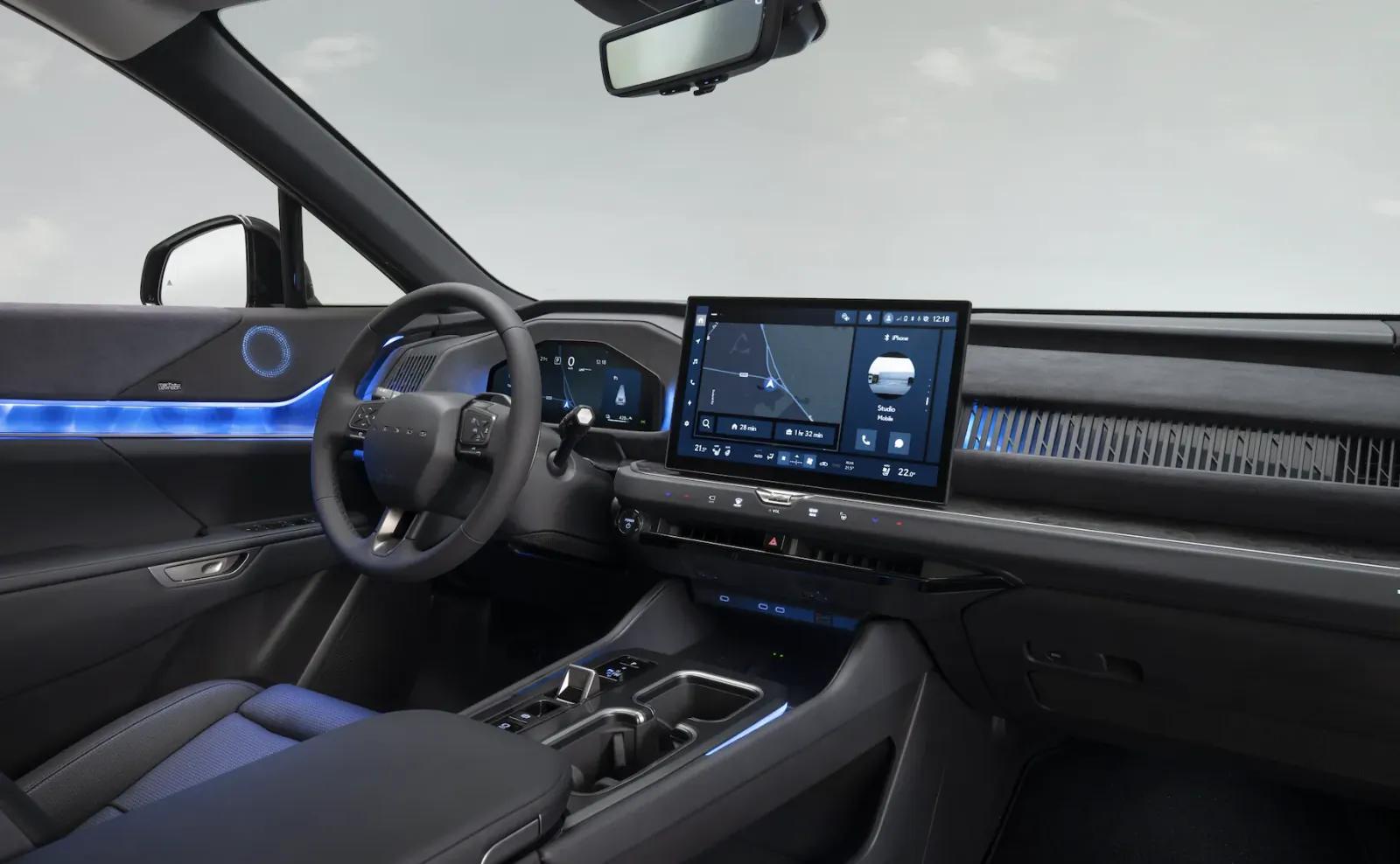 Lexus electric SUV interior with steering wheel, large touchscreen showing navigation, and blue ambient lighting