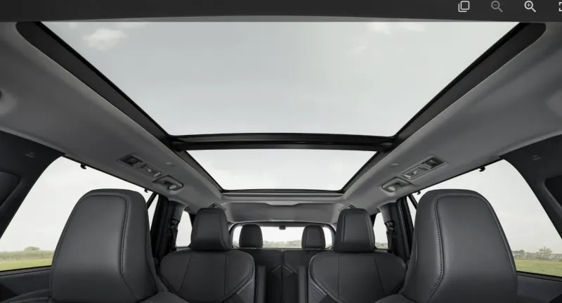 Interior view of a luxury SUV with panoramic glass roof and black leather seats