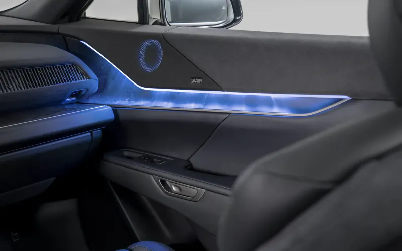 Lexus electric SUV interior with blue ambient lighting on the door panel