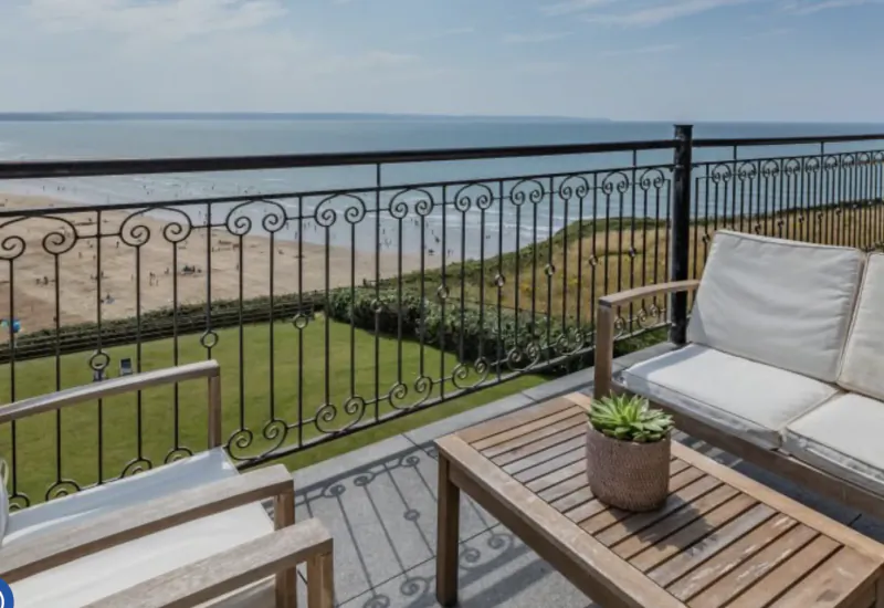 Balcony with wooden furniture overlooking Saunton Sands beach and ocean