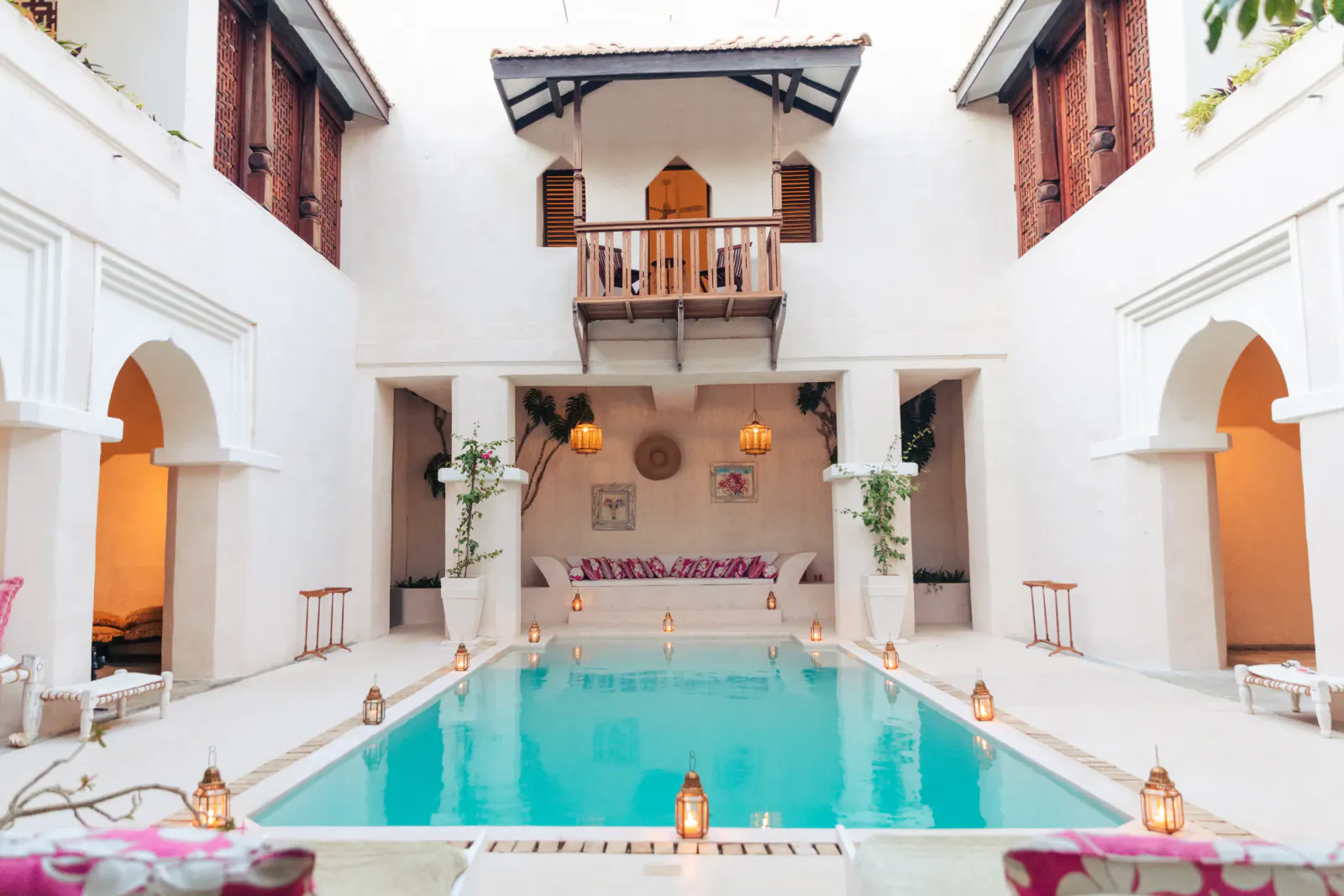 Courtyard pool at The Fort Shela Kenya villa with lanterns, seating, and upper balcony