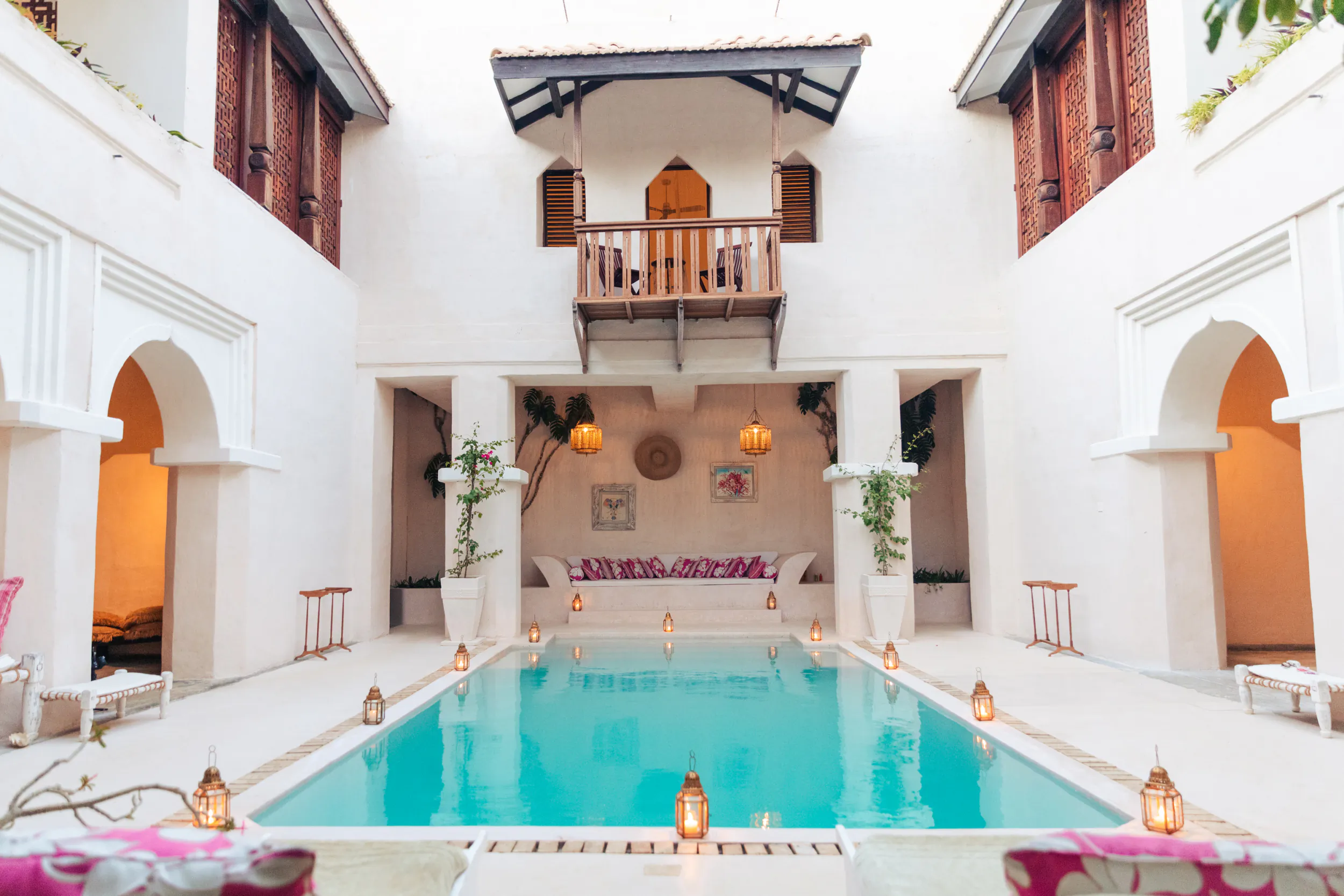 Courtyard pool at The Fort Shela Kenya villa with lanterns, seating, and upper balcony