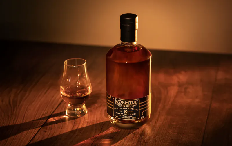 Wormtub 10 Year Old whisky bottle and a glass of whisky on a wooden table