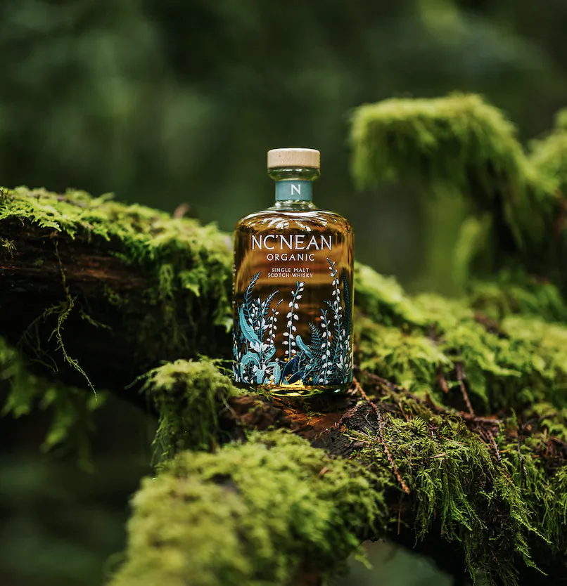 Nc'nean Organic single malt Scotch whisky bottle on mossy forest log