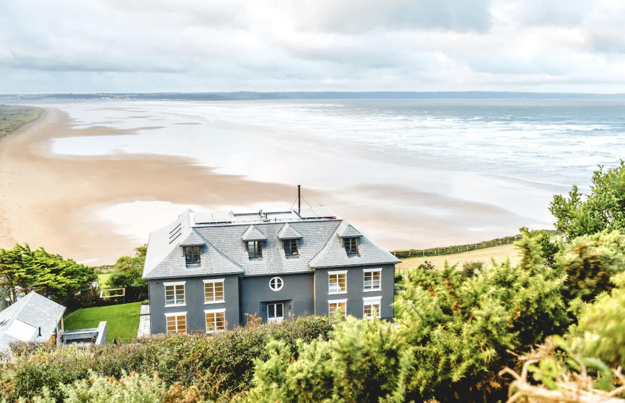 Grey seaside house overlooking sandy beach and ocean at Saunton Sands